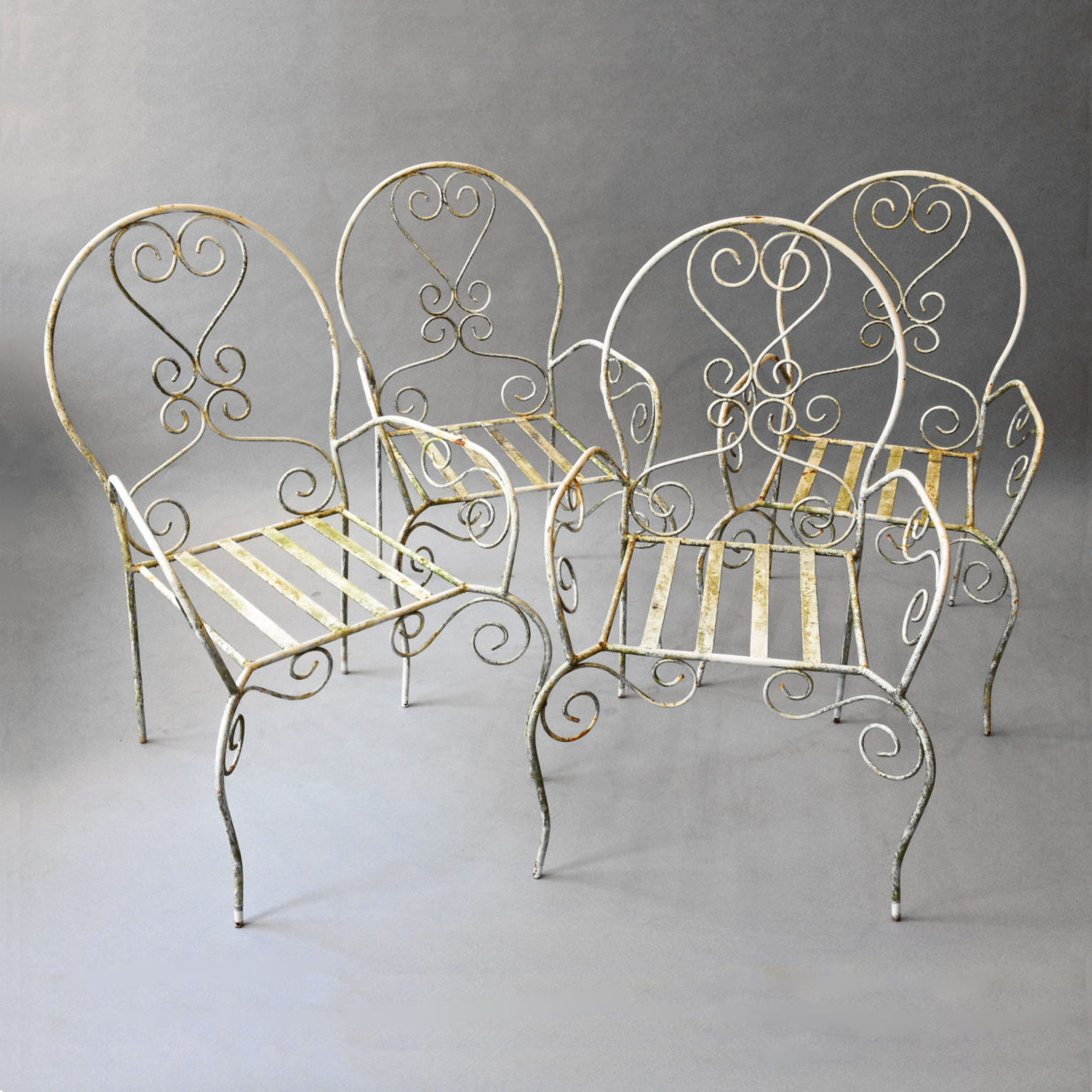 A set of four painted cast and wrought iron garden chairs