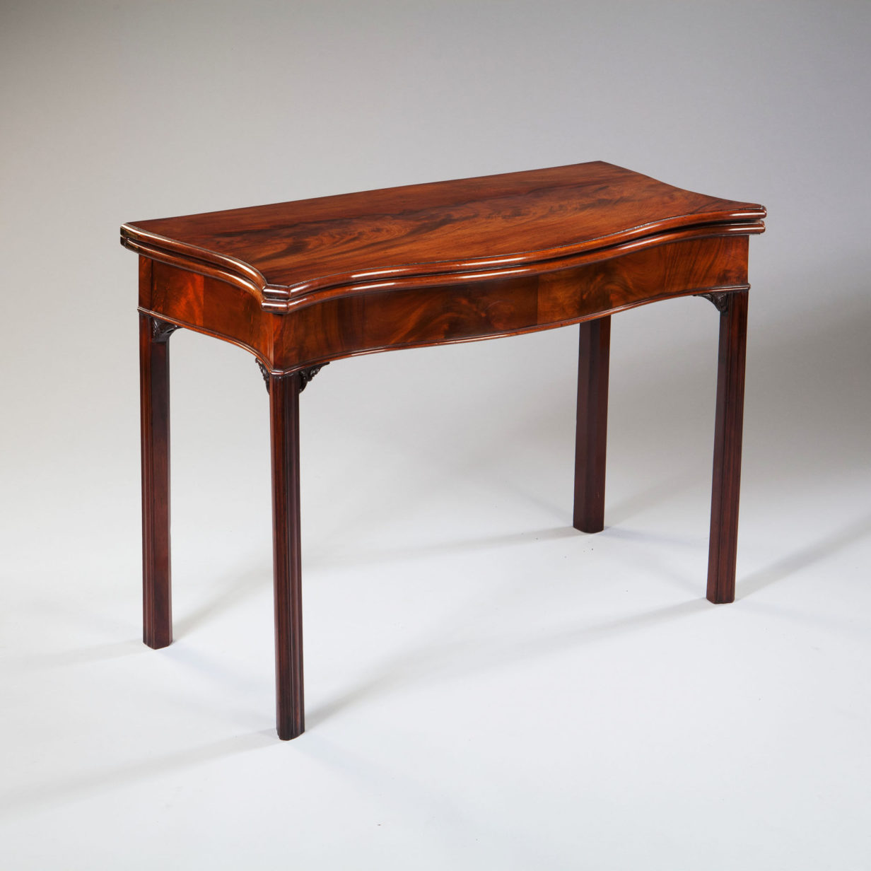 An 18th century george iii period serpentine mahogany card table