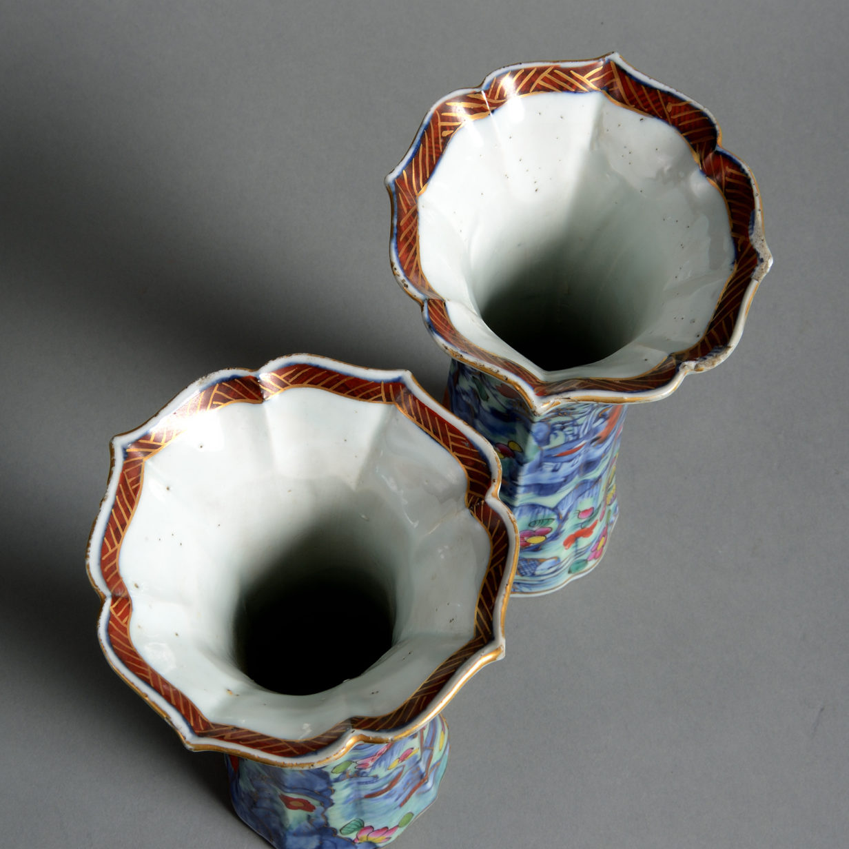 A pair of 18th century clobbered porcelain trumpet vases