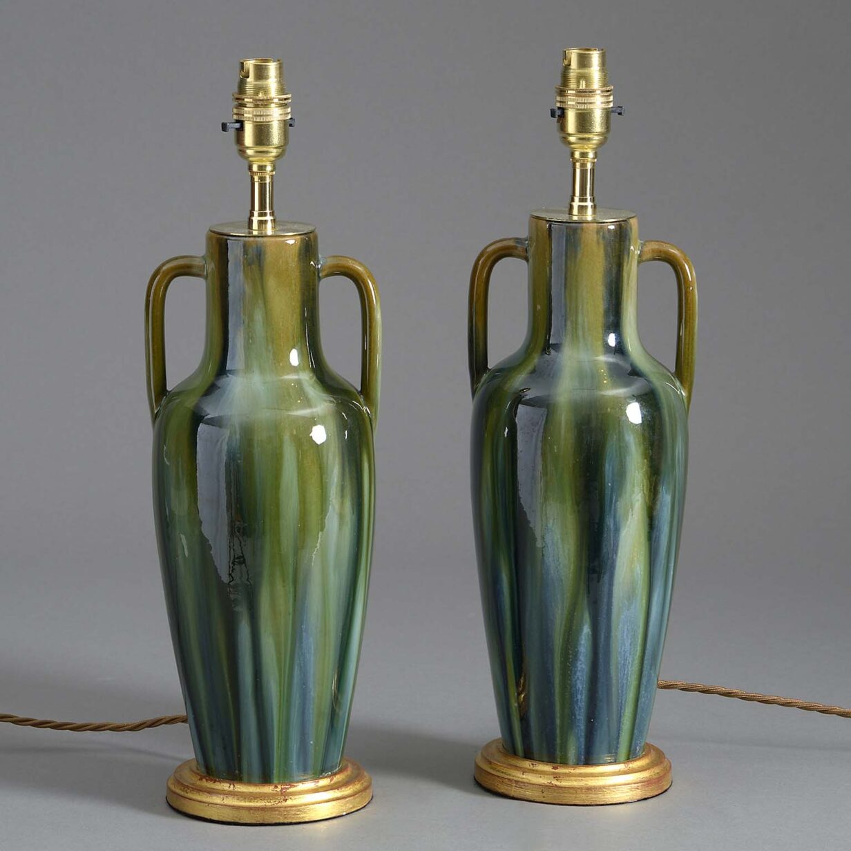 Pair of antique slop glazed pottery lamps